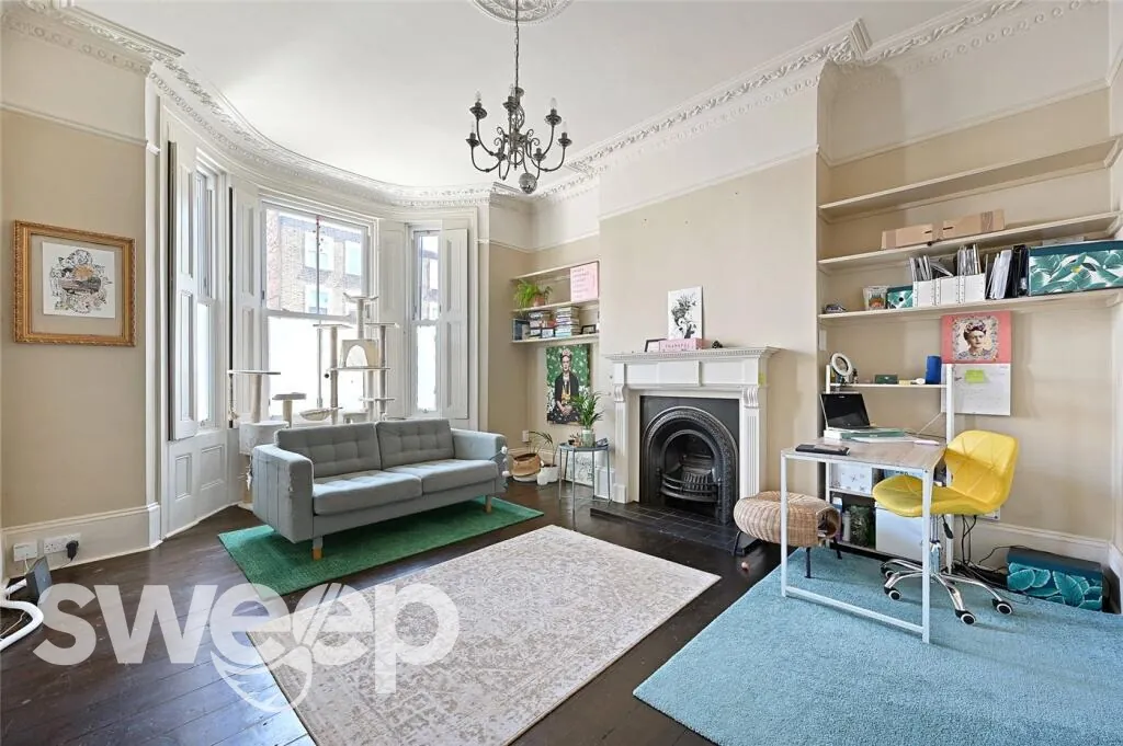 A clean Victorian living room with period fireplace